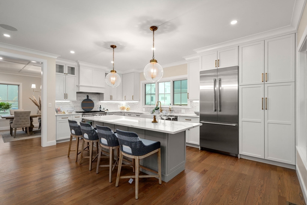 106 Horrigan Drive, Unit 21 Dedham, MA 02026 - Photo 6 of 32 a kitchen with stainless steel appliances granite countertop a sink a stove a refrigerator and island with wooden floor