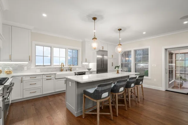 a kitchen with a dining table chairs wooden floor and appliances