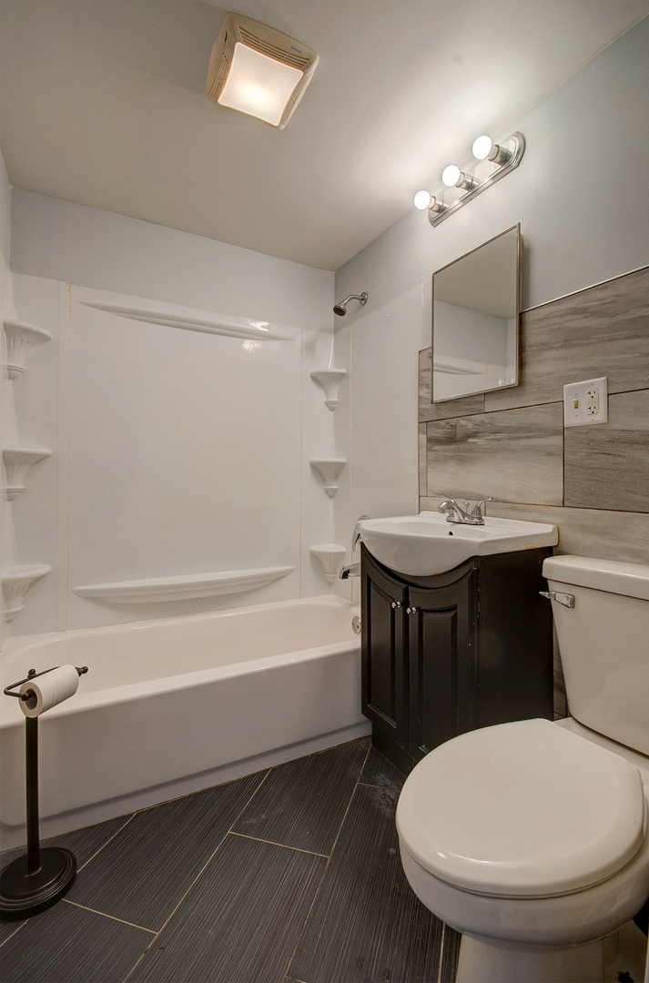 2024 Plainfield Road Crest Hill, IL 60403 - Photo 17 of 20 a bathroom with a sink a toilet a mirror and bathtub