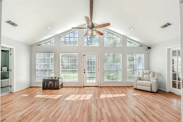 a view of a livingroom with furniture wooden floor and windows