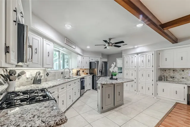 a kitchen with stainless steel appliances kitchen island granite countertop a sink and cabinets