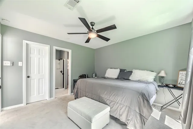a spacious bedroom with a bed and a ceiling fan