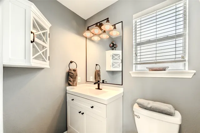 a bathroom with a toilet sink and mirror