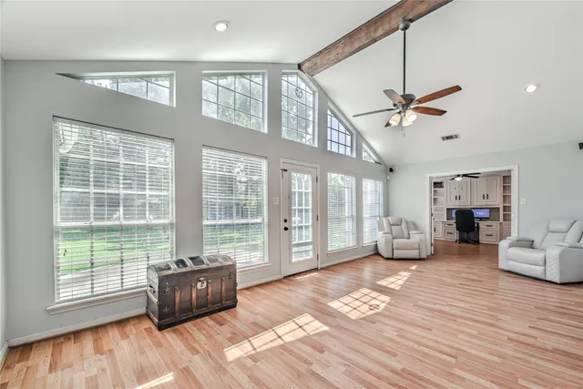 a living room with furniture floor to ceiling window and wooden floor