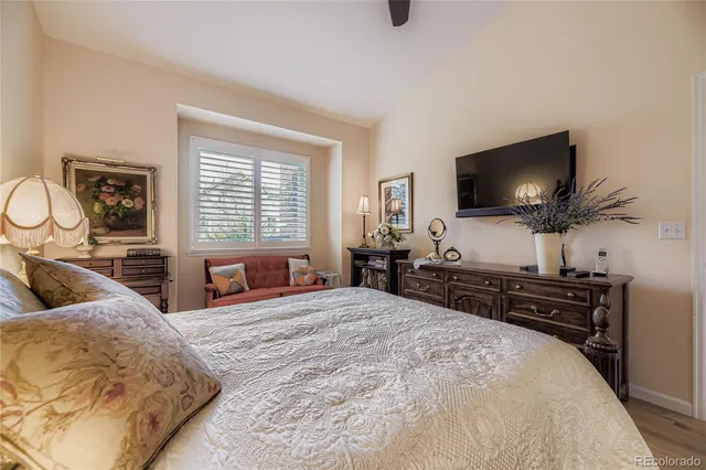 a bedroom with a bed and a flat tv screen on dresser