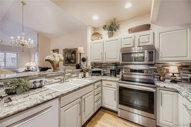 a kitchen with granite countertop a sink stove and cabinets