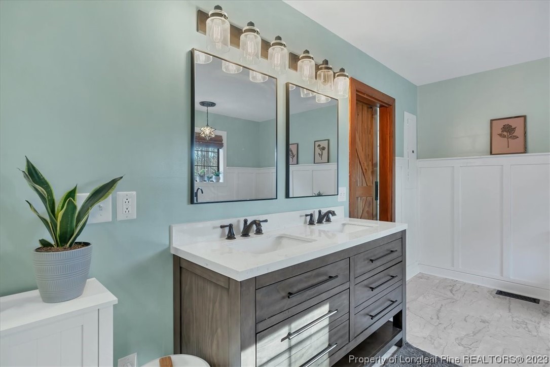 8199 Calloway Road Aberdeen, NC 28315 - Photo 25 of 50 a bathroom with a sink a mirror and a potted plant