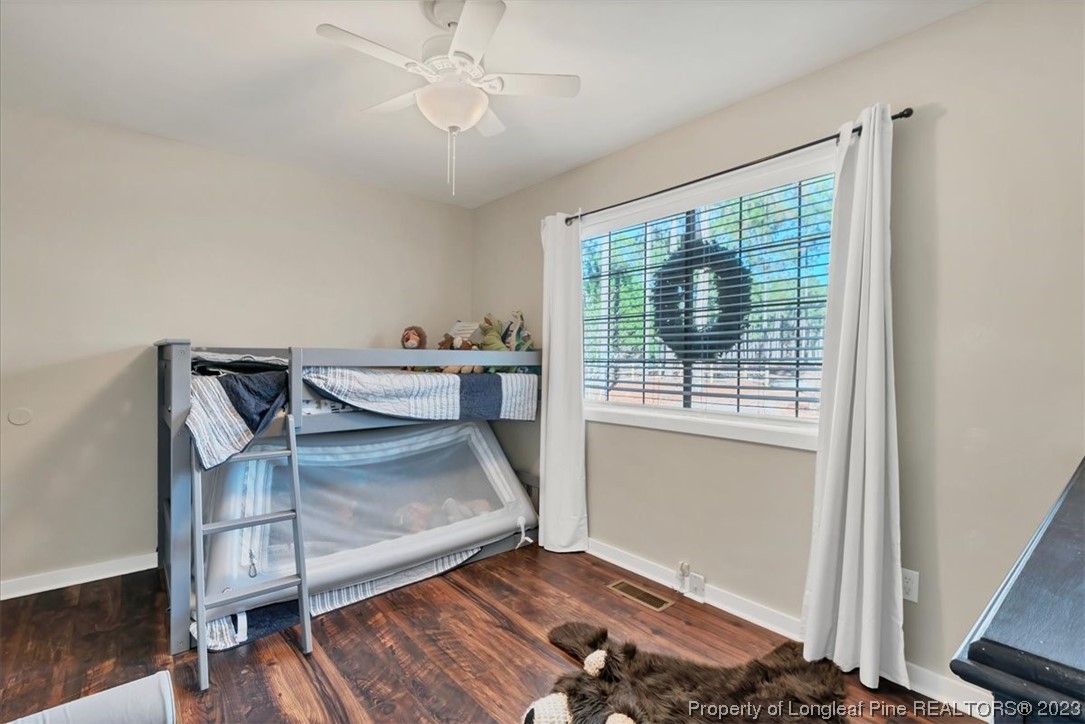 8199 Calloway Road Aberdeen, NC 28315 - Photo 27 of 50 a bedroom with a bed and wooden floor