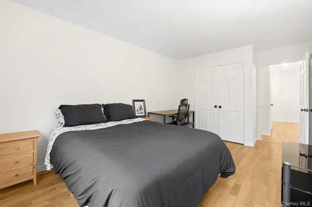 a bedroom with a bed and wooden floor