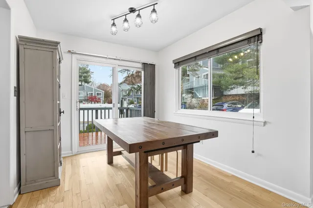 a dining room with wooden floor a glass table and chairs