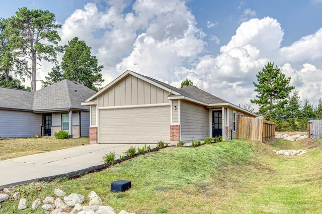 a front view of house with yard and trees around