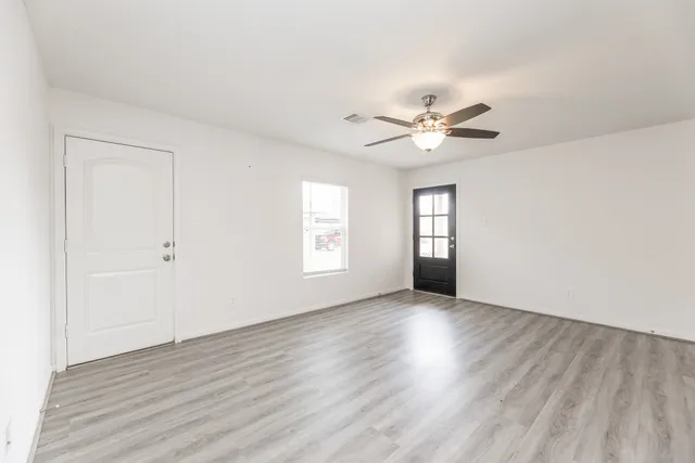 an empty room with wooden floor and window