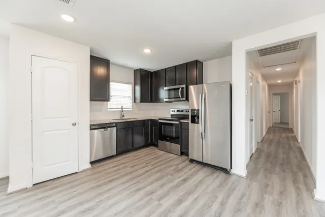 a kitchen with stainless steel appliances a refrigerator and a stove top oven