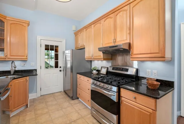 a kitchen with granite countertop a stove a sink dishwasher and a refrigerator
