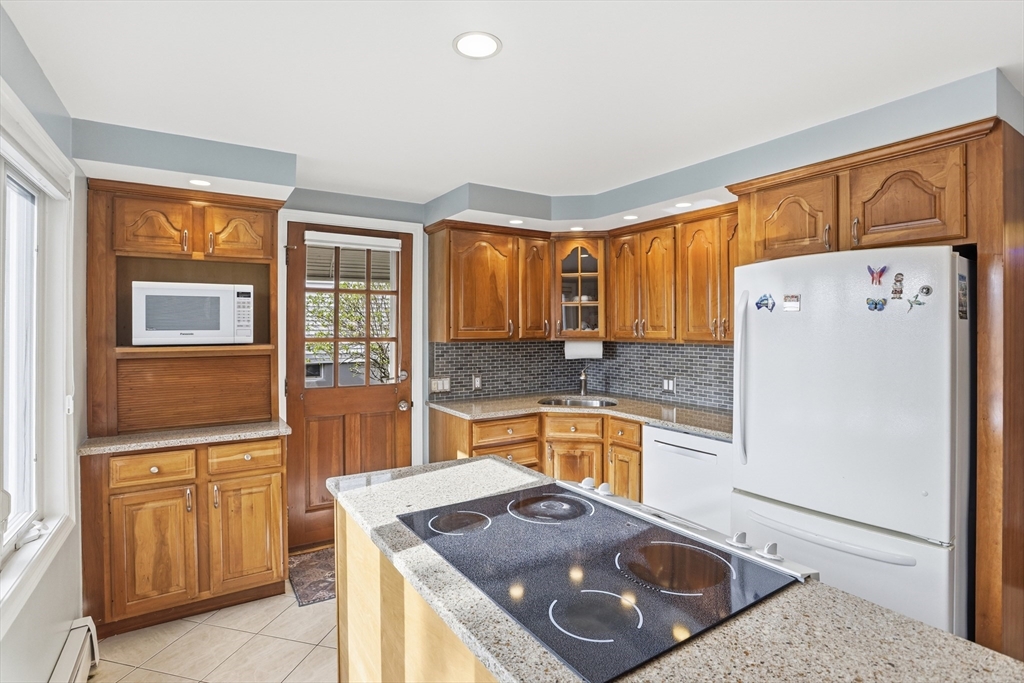 115 Collincote Street Stoneham, MA 02180 - Photo 10 of 25 a kitchen with stainless steel appliances granite countertop a refrigerator a stove and a sink with granite countertops