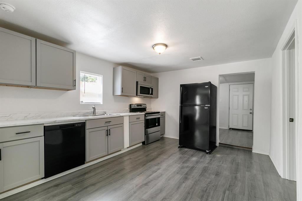 715 Maple Row Denison, TX 75021 - Photo 1 of 1 Kitchen featuring sink, gray cabinetry, black appliances, and light hardwood / wood-style flooring
