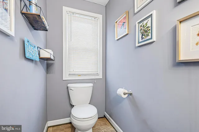 a bathroom with a toilet and a window