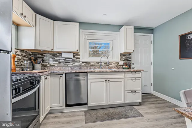a kitchen with stainless steel appliances granite countertop a stove and a sink