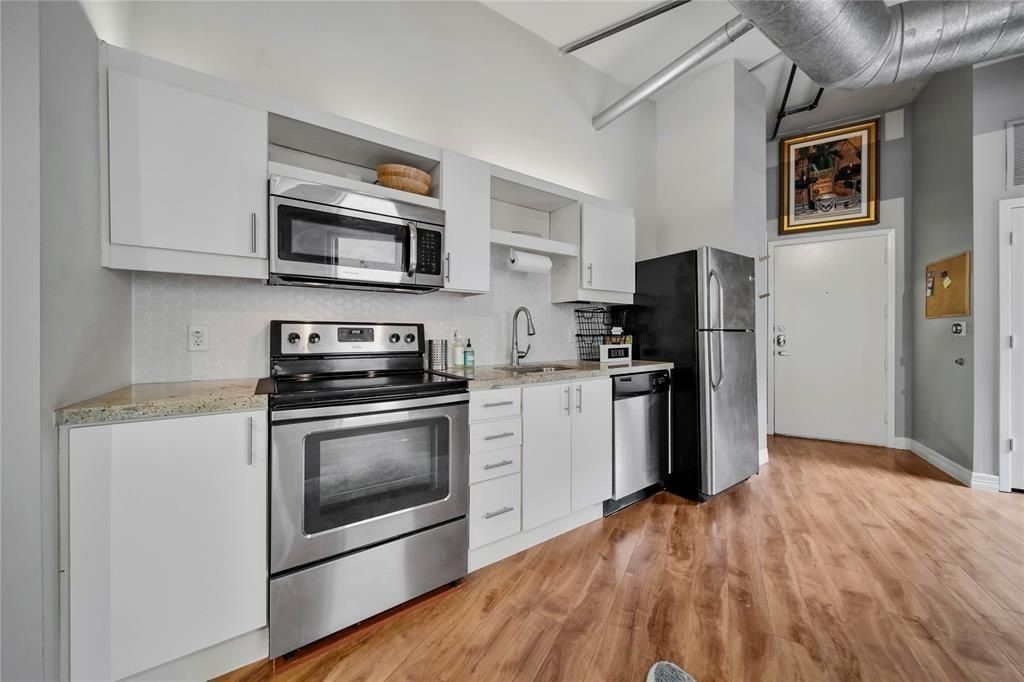 705 Main Street, Unit 610 Houston, TX 77002 - Photo 8 of 15 a kitchen with stainless steel appliances a stove microwave and a refrigerator