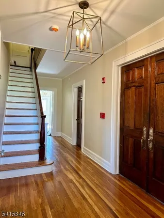 a view of a hallway with wooden floor and staircase