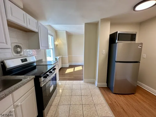 a kitchen with granite countertop a refrigerator and a stove