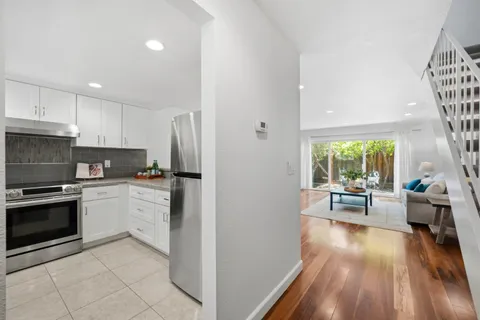 a kitchen with a sink a refrigerator and wooden floor