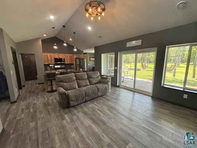 3454 Anderson Road Hibbing, MN 55746 - Photo 3 of 31 Expansive living area with wood-finish flooring, vaulted ceilings, and a sliding glass door leading to an outdoor patio