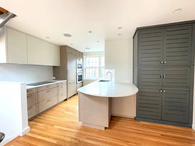 a kitchen with stainless steel appliances cabinets and wooden floor