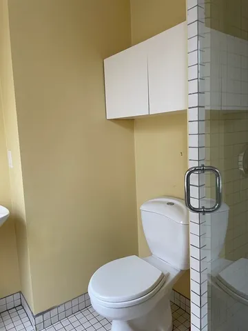 a white toilet sitting next to a shower