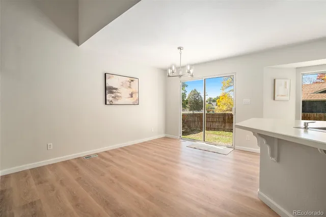 a view of a kitchen with furniture and wooden floor