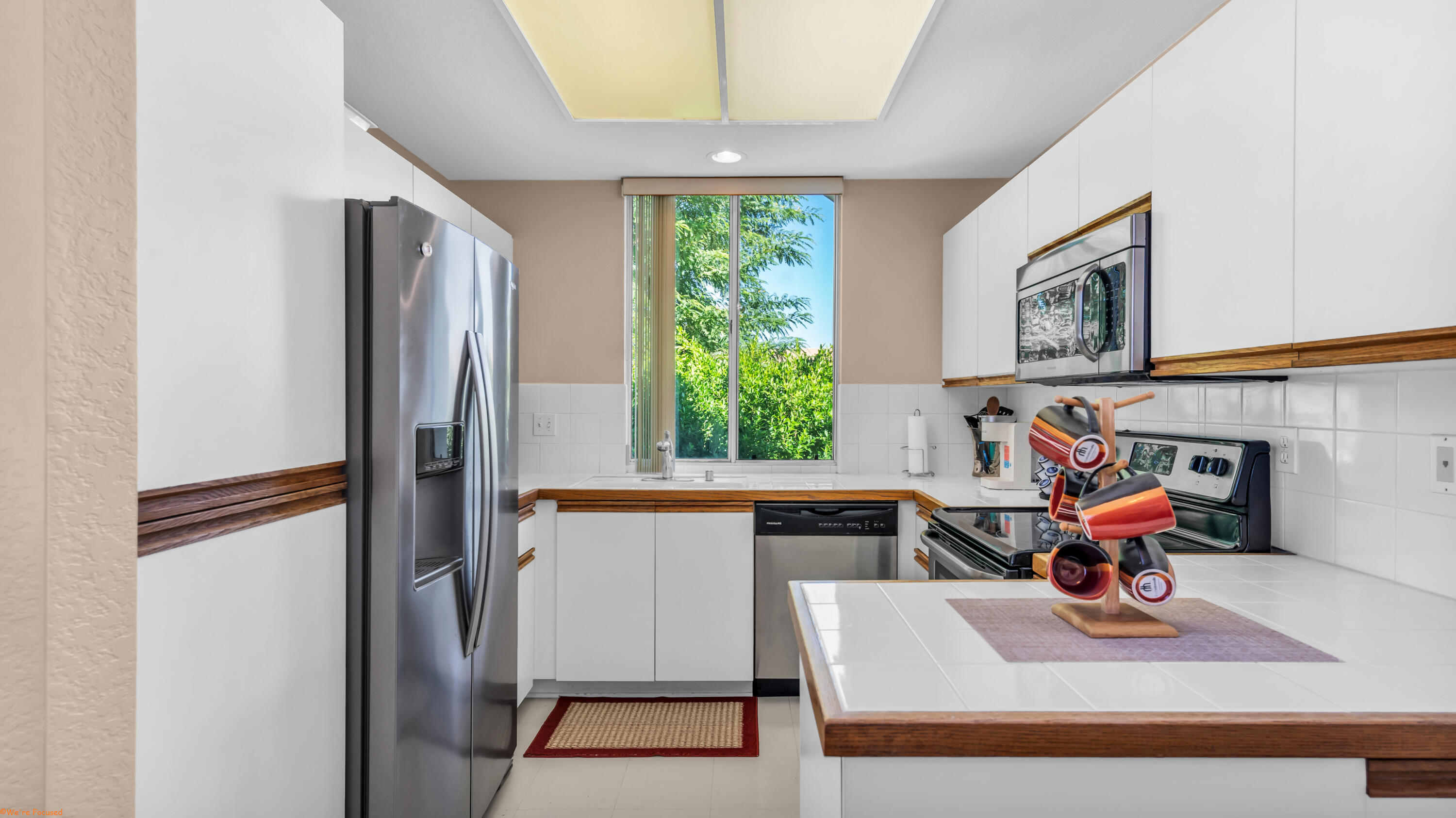 401 El Cielo Road, Unit 236 Palm Springs, CA 92262 - Photo 4 of 29 a kitchen with stainless steel appliances granite countertop a refrigerator and a sink