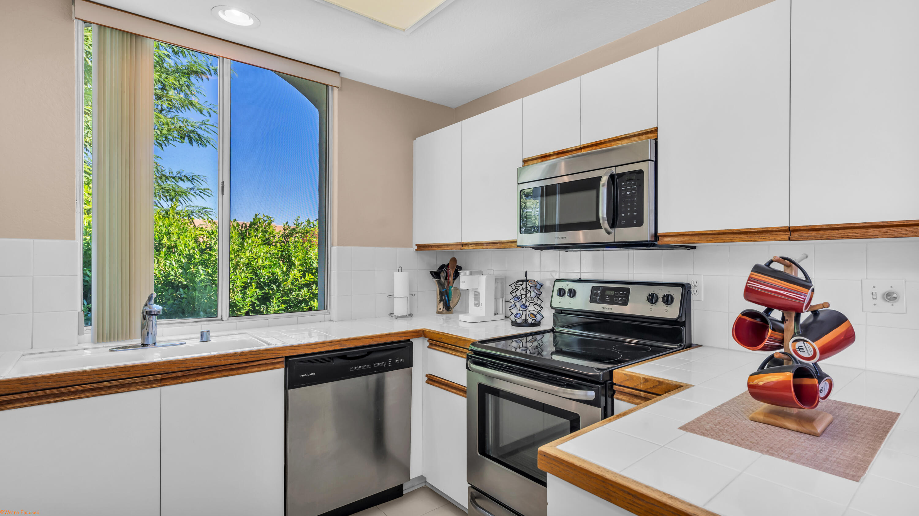 401 El Cielo Road, Unit 236 Palm Springs, CA 92262 - Photo 5 of 29 a kitchen with stainless steel appliances a stove a microwave and cabinets