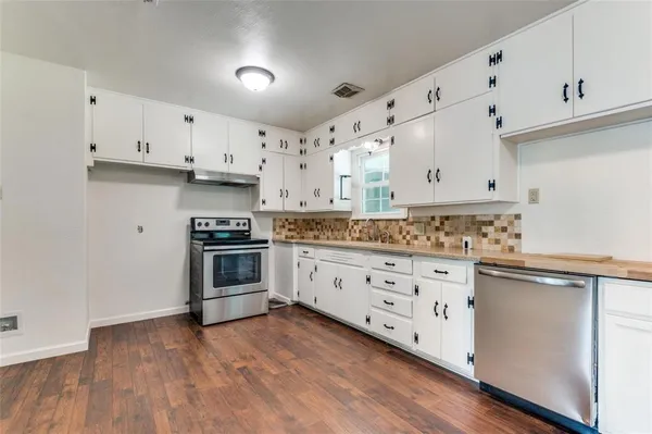 a kitchen with granite countertop white cabinets and white appliances