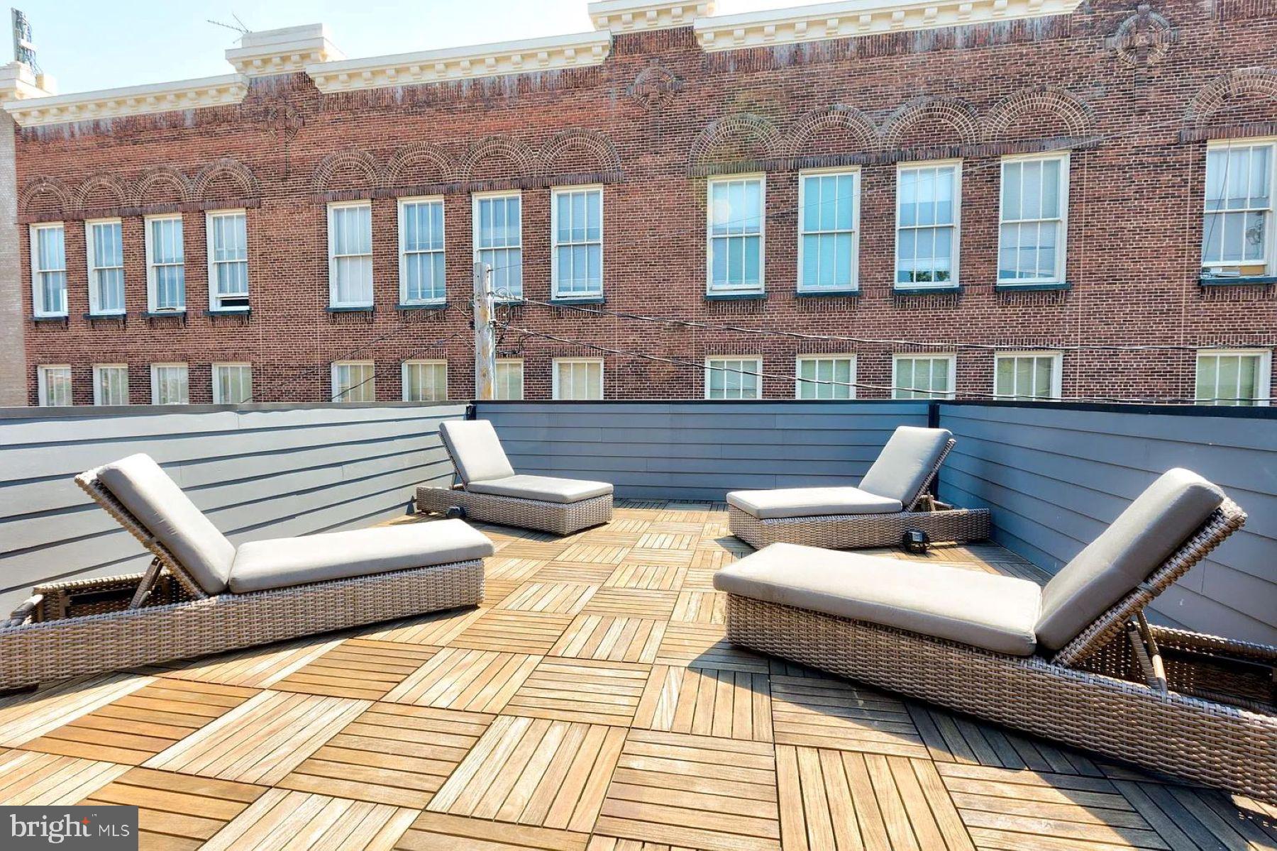 1617 Eastern Avenue, Unit 201 Baltimore, MD 21231 - Photo 12 of 13 a view of a patio with couches and a dining table and chairs with wooden floor