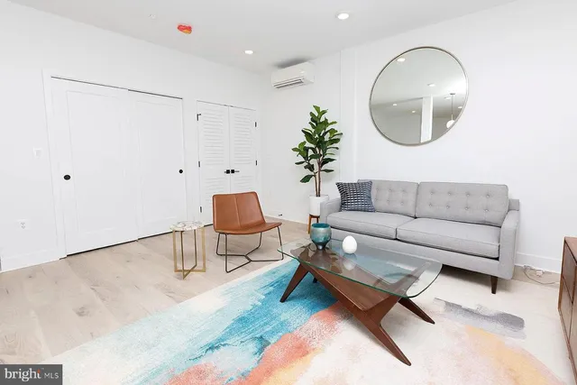 a living room with a couch and a potted plant