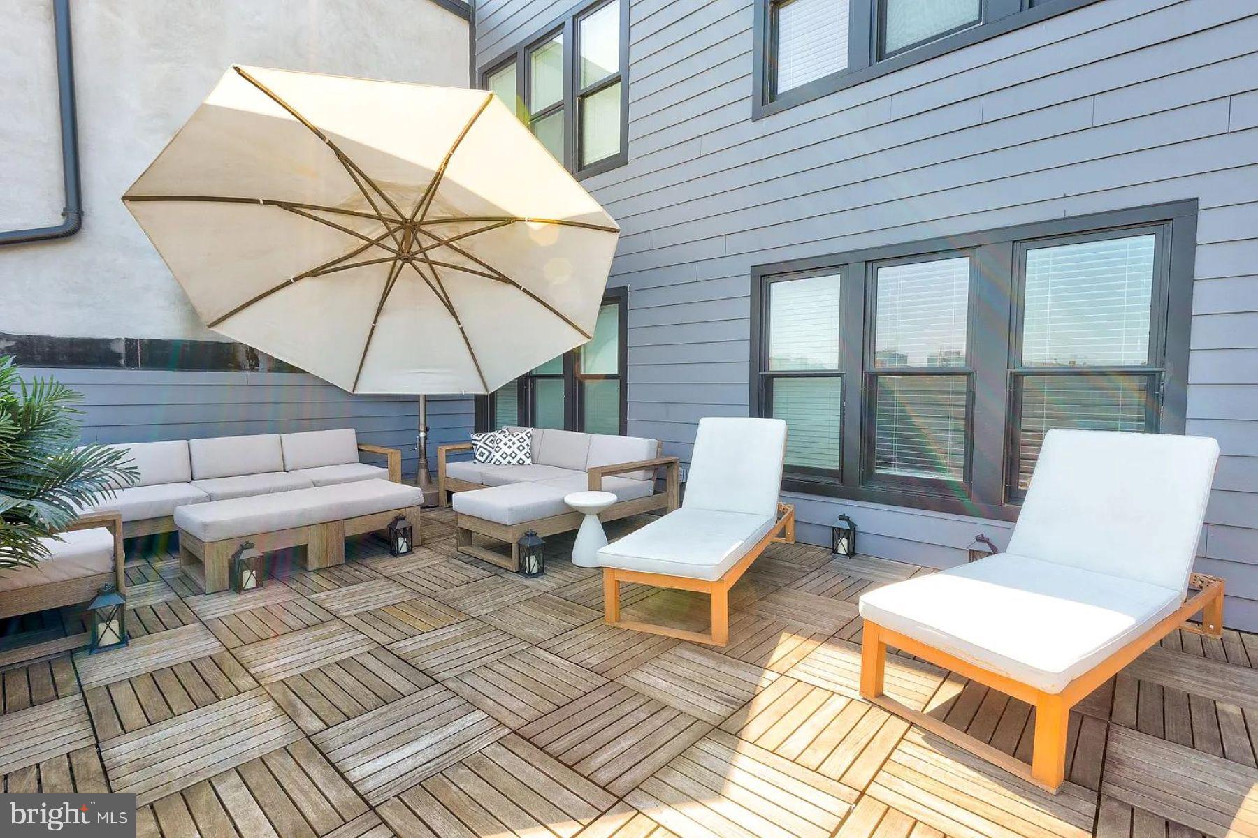 1617 Eastern Avenue, Unit 201 Baltimore, MD 21231 - Photo 10 of 13 a couple of table and chairs under an umbrella