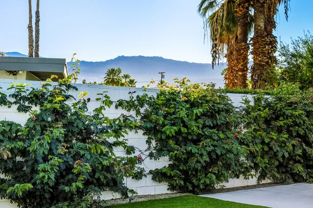 a living room with furniture kitchen view and a large window