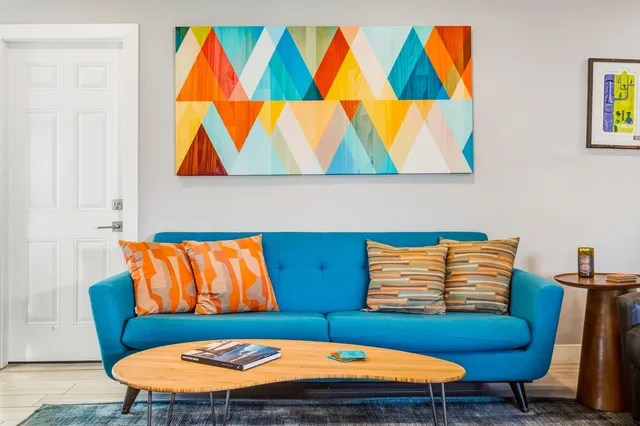 a living room with furniture a rug and a wall painting