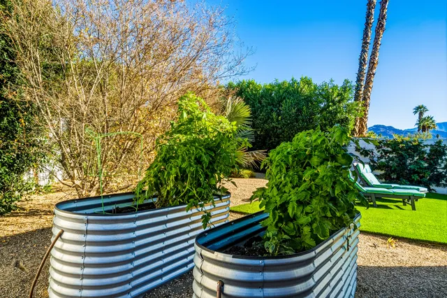 a view of an outdoor dining space with a table and chairs under an umbrella
