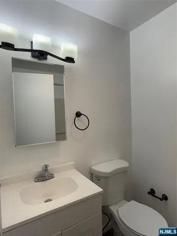 a bathroom with a sink a toilet and mirror