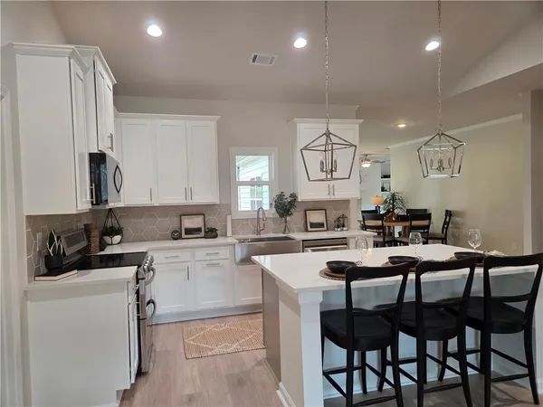 a kitchen that has a table in it and stainless steel appliances