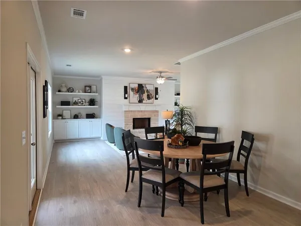 a dining room with furniture and kitchen view