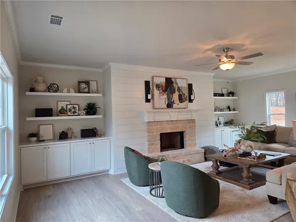 a living room with furniture a fireplace and wall paintings