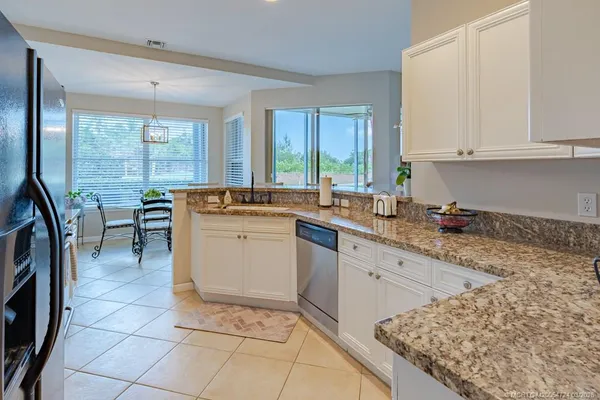a kitchen with granite countertop a sink a stove and cabinets