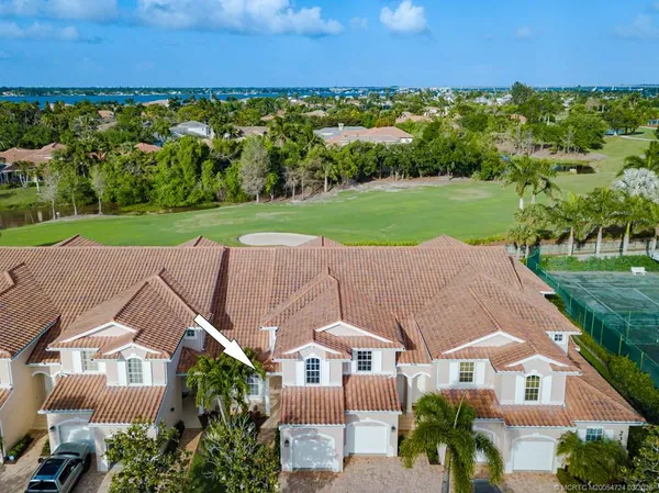 an aerial view of residential houses with outdoor space and trees