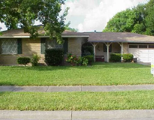 a front view of a house with a garden and yard