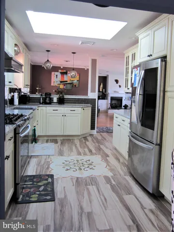 a kitchen with stainless steel appliances granite countertop a refrigerator and cabinets