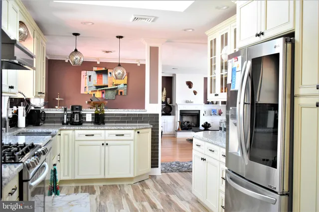 a kitchen with stainless steel appliances granite countertop a sink dishwasher and cabinets with wooden floor