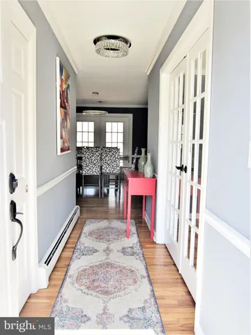 a living room with furniture kitchen view and a wooden floor