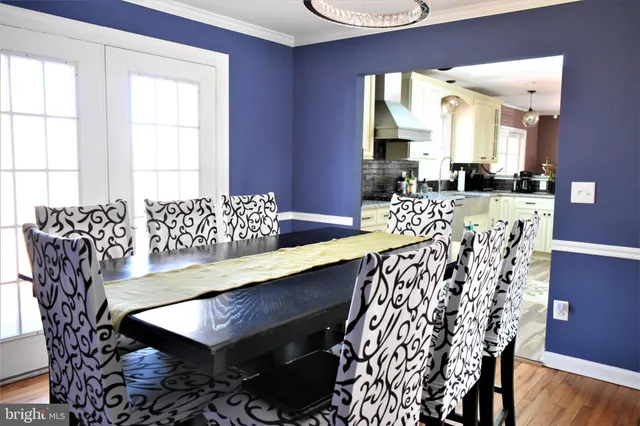a view of a dining room with furniture a chandelier and wooden floor